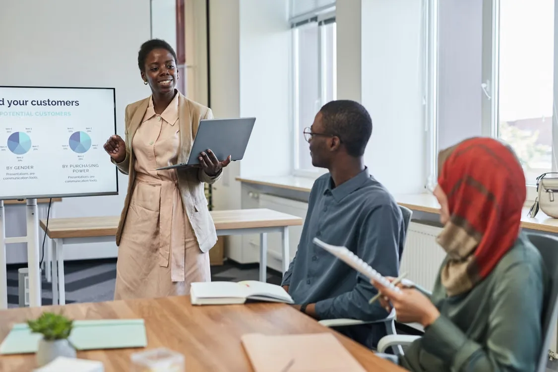 A businesswoman presenting charts to colleagues in a meeting room